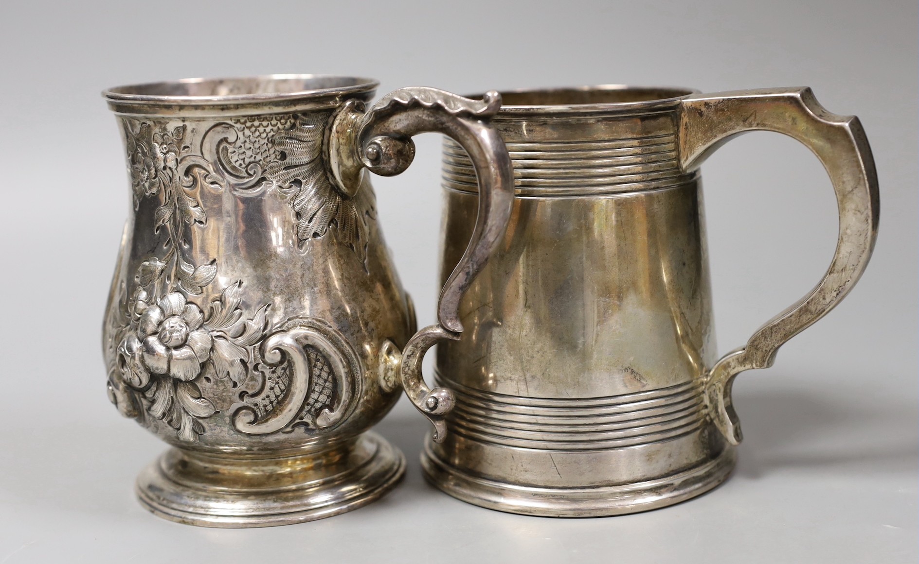 A George V silver mug, with reeded bands, Elkington & Co, Birmingham, 1935, 11.5cm and a Victorian repousse silver baluster mug, Robert Harper, London, 1862, 23.8oz.